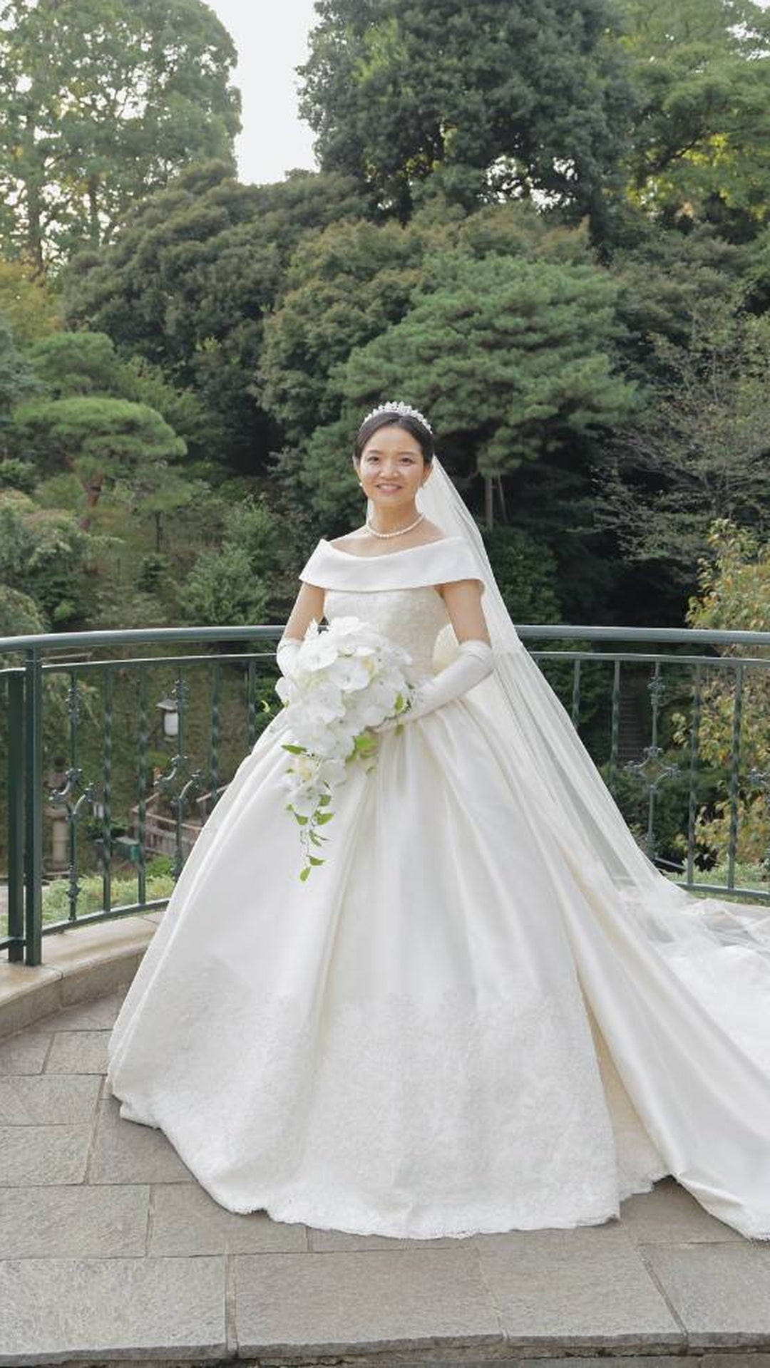 椿山荘東京の庭園で胡蝶蘭のキャスケードブーケを持つ花嫁様