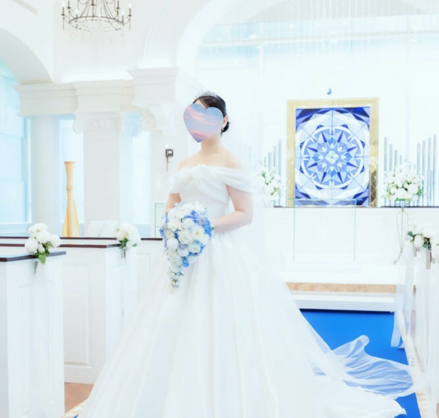 白いウェディングドレスの花嫁様が、青と白の手作りキャスケードブーケを手にされたチャペルでのお写真