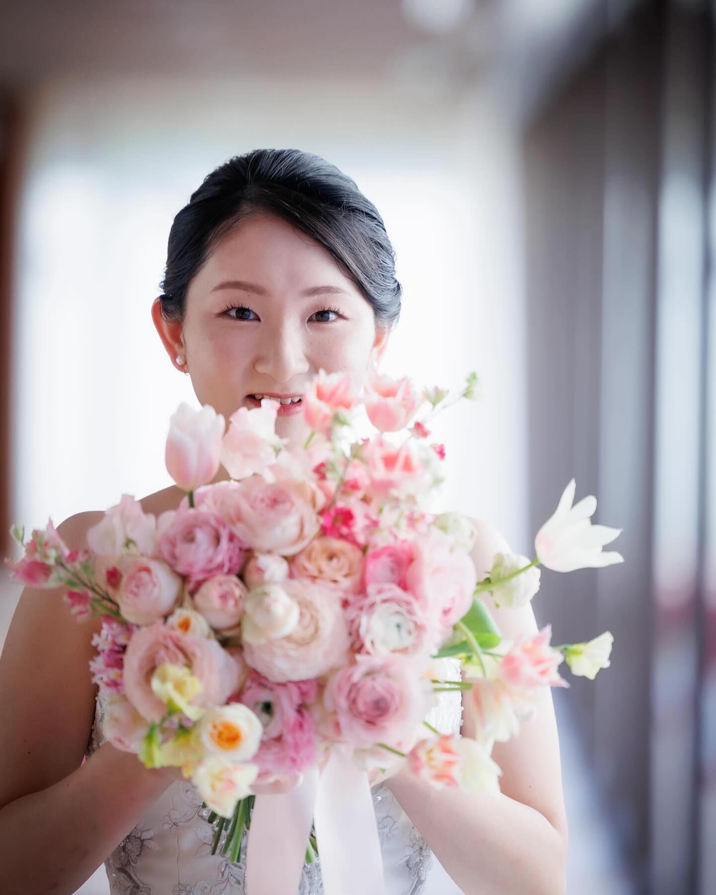 ピンクのラナンキュラスとチューリップの春色ブーケを手にされた帝国ホテルの花嫁様