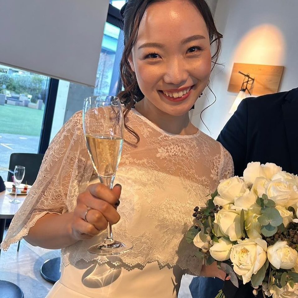 白いバラのクラッチブーケを手に微笑む、ビサイドシーサイドの卒花嫁様