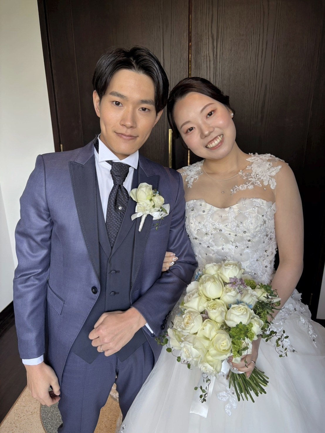 クラシカ表参道の花嫁様と新郎様。白いバラとブルースターのクラッチブーケを手に