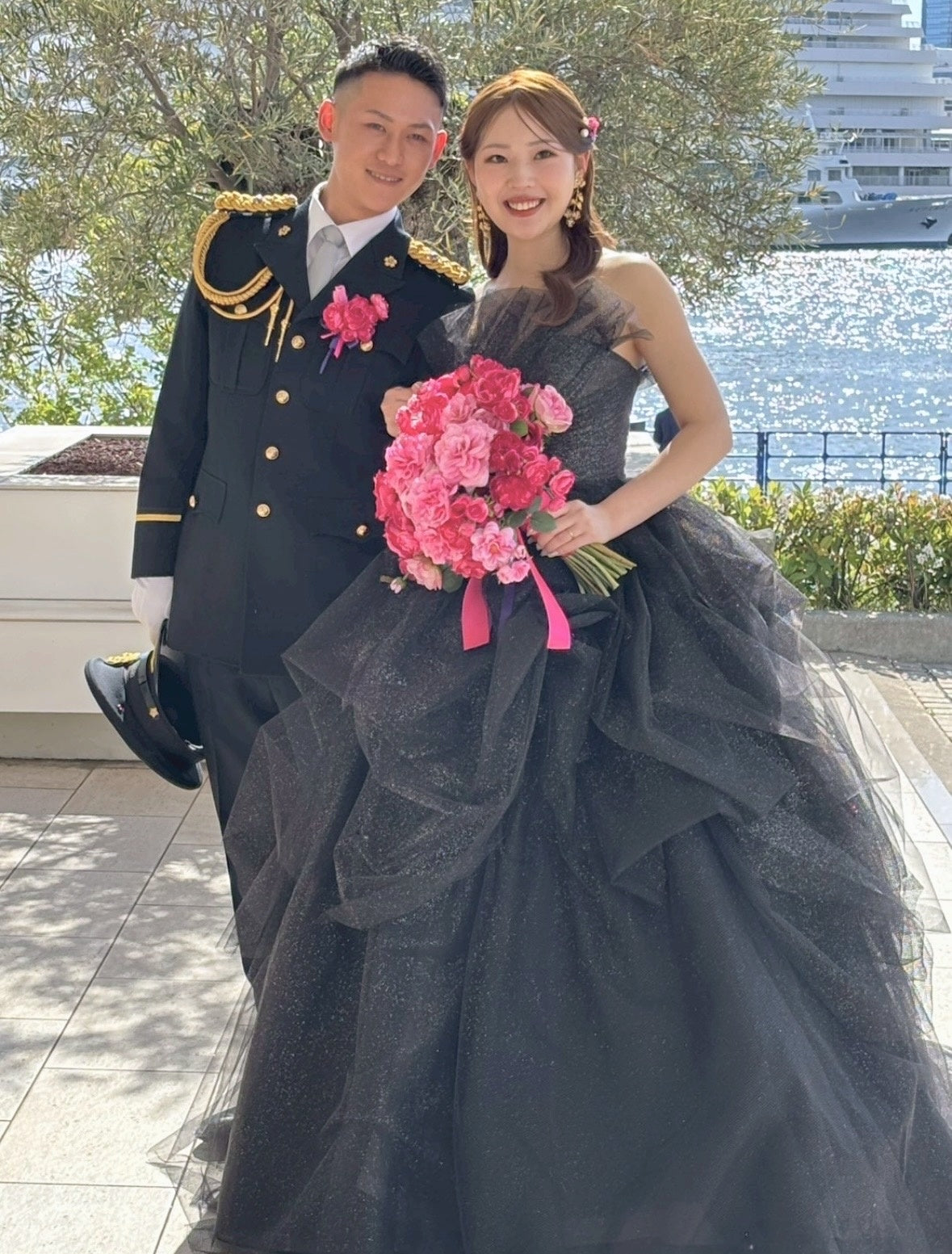 黒のカラードレスにローズピンクのクラッチブーケをお持ちの花嫁様と、礼服にお揃いのブートニアをつけたご新郎様｜ラ・スイート神戸オーシャンズガーデン