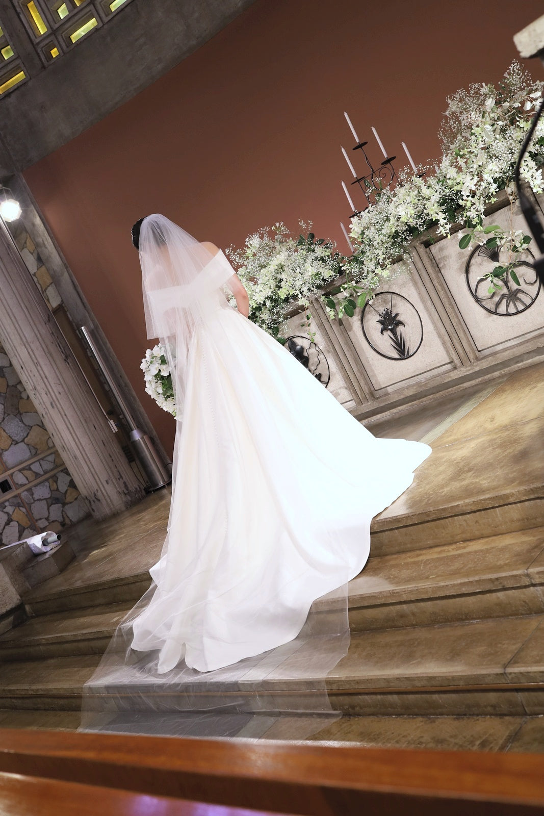 東京女子大学チャペルの祭壇へ向かう花嫁様の後ろ姿と、胡蝶蘭のキャスケードブーケ